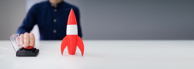 Businessman's Hand Launching Rocket