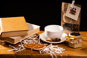 Brown book on table in decor interior with empty cup, gift leave black tea on table. Elements of decor, Cafe, empty cup, design of intreior, cozy 