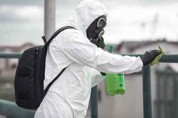 Quarantine, coronavirus infection. A man in protective equipment disinfects with a sprayer in the...