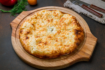 khachapuri with cheese on brown concrete table