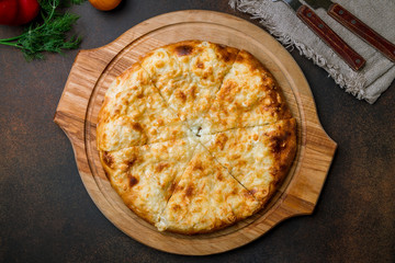 khachapuri with cheese on brown concrete table