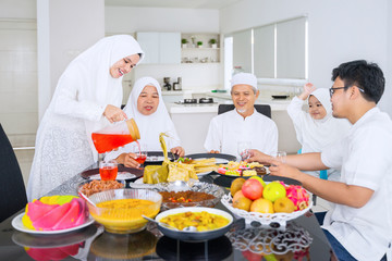 Obraz na płótnie Canvas Happy muslim family eating together in dining room
