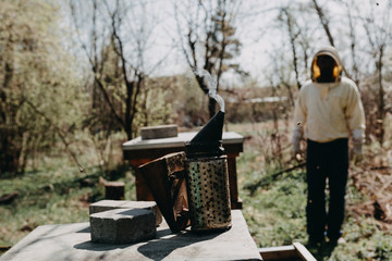 Chimney for flashing bees. Chimney stands near beehives.The beekeeper's tool. Bee smoker smoking.