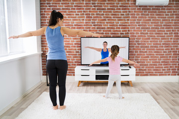 Fototapeta na wymiar Family Doing Home Online Yoga Fitness Exercise
