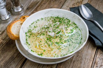 Chicken soup bouillon on a bowl on wooden table