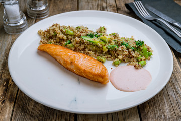 Salmon steak on the grill with quinoa on wooden table