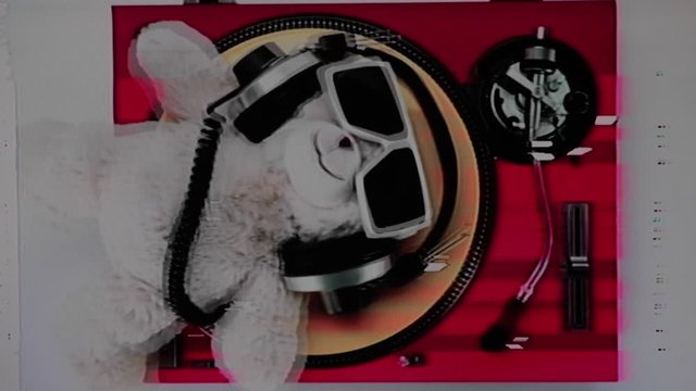 a dj teddy bear lying on turntables with glitch