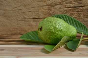 fresh crystal guava fruit on green leaf with wooden board.