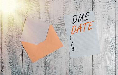 Handwriting text Due Date. Conceptual photo The date when payment should be received by the demonstrating or company Front view open colored envelope blank sheet letter paper wooden background