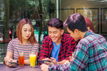 Young man and his friends looking at smartphone