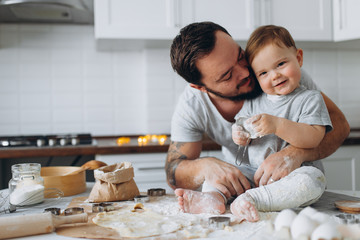 Fototapeta premium happy family in the kitchen. father and son preparing the dough, bake cookies