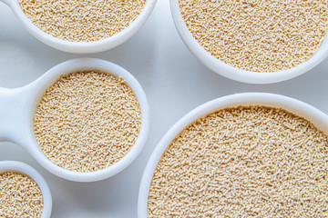 A close up of some measurement baking spoons with yeast on them