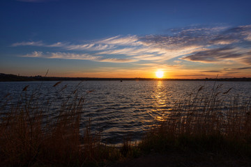 Beautiful sunset on the lake with clouds and reflections on the water