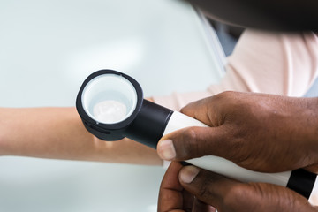 Female Doctor Examining Skin Of Female Patient