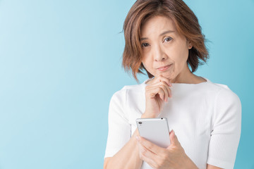スマートフォンを見るシニア女性　考える