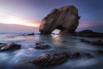 This boulder, called by locals like "Penedo do Guincho" due the sound like a scream that wind produces when passes for their hole, is in Santa Ana Beach, in Torres Vedras.