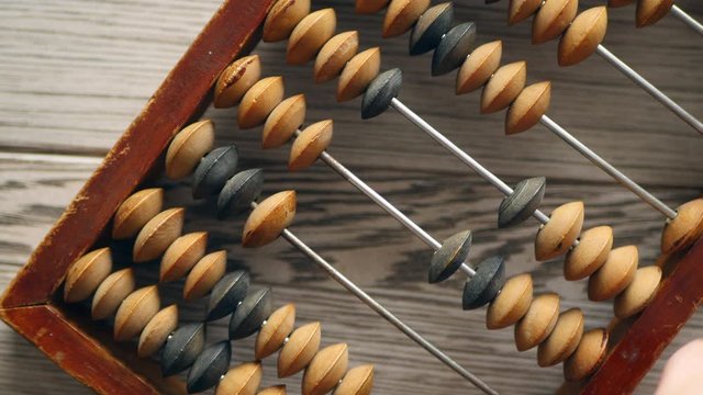 A Elderly Man Moves Wooden Knuckles On A Outdated Vintage Wooden Abacus On A Gray Desk, Close-up On The Right Side. Natural Daylight.