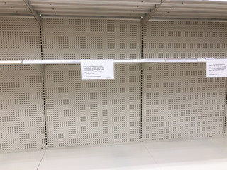 Empty toilet paper shelf in grocery stores after panic buying due to Coronavirus pandemic. © dina