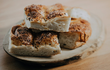 Turkish Ramadan Bread - Ramazan Pidesi on wooden table with yellow background. Popular food in Ramadan. Homemade pie.