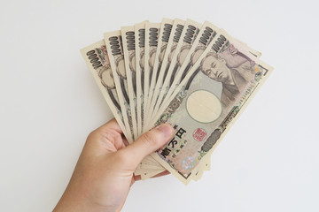 10万円を握る男性の手-白背景