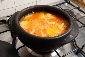 fish being cooked in a clay pot