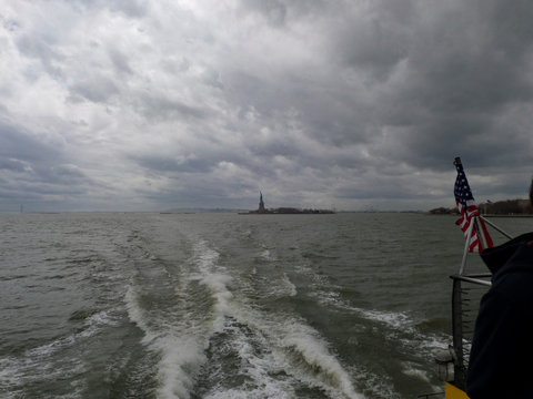 Statue Of Liberty In Hudson River Against Cloudy Sky Seen From Boat