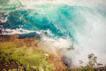 Waves of water of the river meet each other creating SAPPHIRE colours and swirling water - whirlpools. Rainbow and green grass.