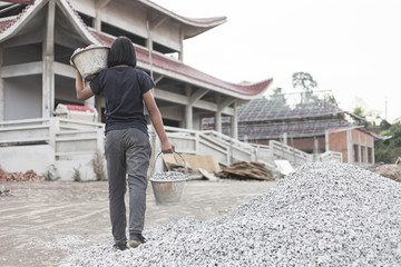 poor young girl working at construction site for world day against child labor concept:
