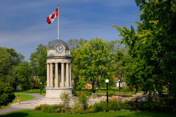 Old City Hall Clock Tower and fountain in Victoria Park Kitchener with Canadian flag