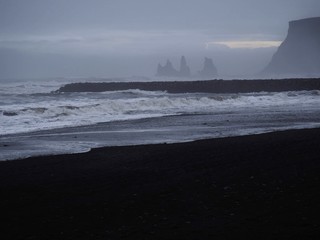 A scenery of a South Iceland beach (Reynisfjara), black sand beach, foamy sea water, Rushing waves,...