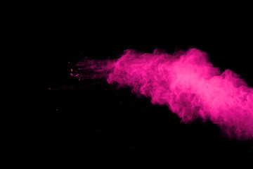 Pink powder explosion on black background. Colored cloud. Colorful dust explode. Paint Holi.