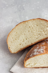 Artisan rustic bread from wheat flour on light grey stone background, selective focus. 