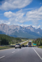 POV from the front of moving car while driving on super highway among national park in north america-canada in summer daytime