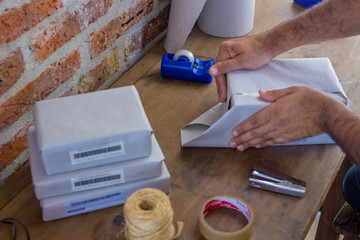 `man assembling packages at home to deliver parcels - top