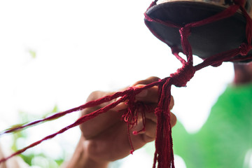 Hand of a craftsman knitting handmade macrame.