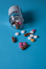 Homeopathic globules and glass bottle on blue background. Alternative Homeopathy medicine herbs, healtcare and pills concept. Flatlay. Top view. copyspace for text.