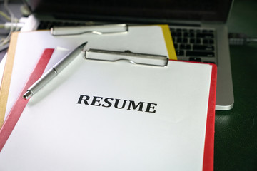 Closeup of resume on top of computer laptop on table