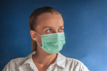 girl in a medical mask on a dark blue background