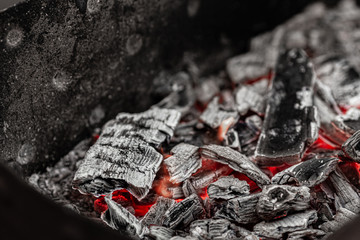 Hot white and black coals smolder in the grill