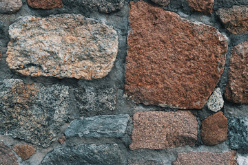 Background of old stone wall with stones of different sizes and colors.