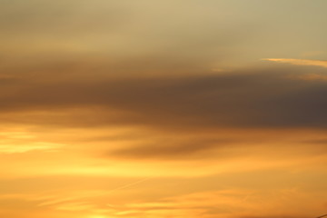 Sun below the horizon and clouds in the fiery dramatic orange sky at sunset or dawn backlit by the sun. Place for text and design.