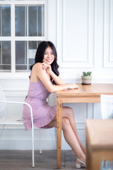 Beautiful Asian woman wear dress pants pink. Sitting on chair and white background.