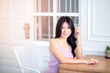 Obraz na płótnie Canvas Beautiful Asian woman wear dress pants pink. Sitting on chair and white background.