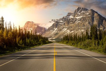 Scenic road in the Canadian Rockies during a vibrant sunny summer sunrise. Sky Composite. Taken in Icefields Parkway, Banff National Park, Alberta, Canada.