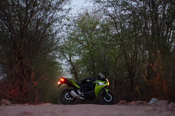 Green motorcycle on a forest road