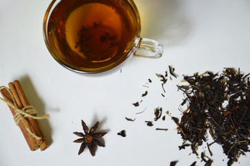 Glass Cup Tea with with cinnamon and anise on White Background.