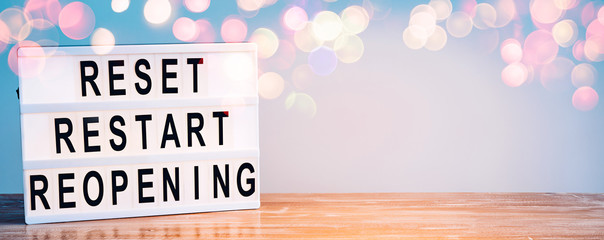 Words reset, restart and reopening on the light box. New life, new business, new deals concept