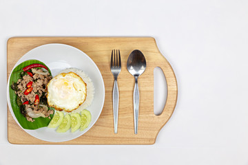 Thai food, fried rice basil pig. Fried minced pork with steam jasmine rice on white plate. delicious Fried minced pork on Banana tree leaves.