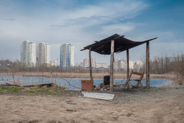 A canopy with a chair on the background of the lake and the city