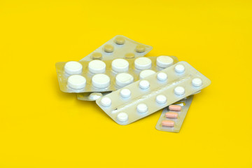 Opioid epidemic, painkiller pills on yellow background